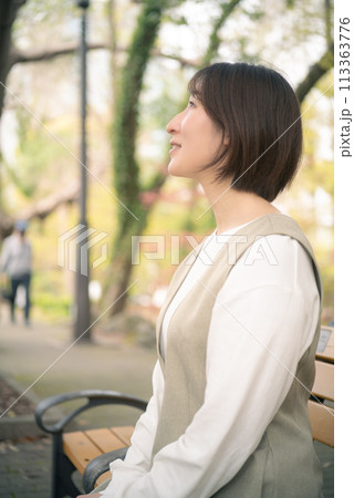 休日に公園を散歩する女性 113363776