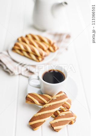 Classic Striped Cookies and coffee cup on white table. Classic Striped Cookies and coffee cup on white table. 113366501