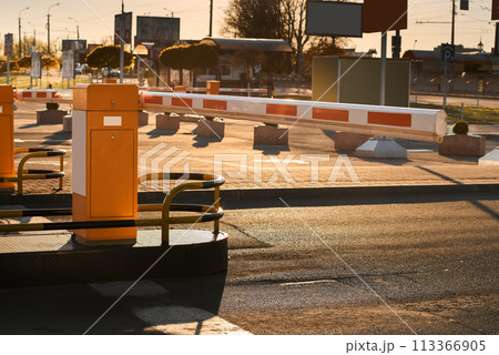 Automatic barrier gates for supermarket parking lot. Security system for car park entry to shopping mall. Vehicle entrance with boom barriers and control tickets machine Automatic barrier gates for supermarket parking lot. Security system for car park entry to shopping mall. Vehicle entrance with boom barriers and control tickets machine 113366905