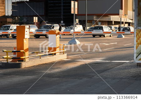 Automatic barrier gates for supermarket parking lot. Security system for car park entry to shopping mall. Vehicle entrance with boom barriers and control tickets machine Automatic barrier gates for supermarket parking lot. Security system for car park entry to shopping mall. Vehicle entrance with boom barriers and control tickets machine 113366914