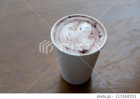 A cup of hot chocolate with latte art on the wooden table 113368551