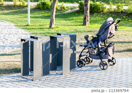 Baby stroller stands near the bicycle parking 113369764