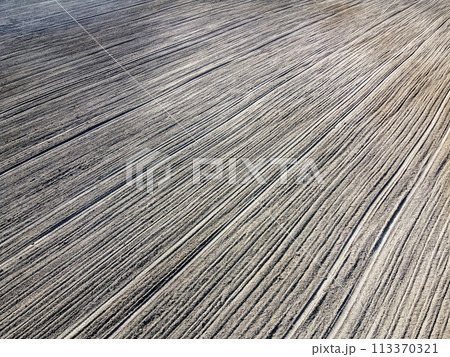 Plowed agricultural field, aerial view. Agricultural land. Background. Plowed agricultural field, aerial view. Agricultural land. Background. 113370321