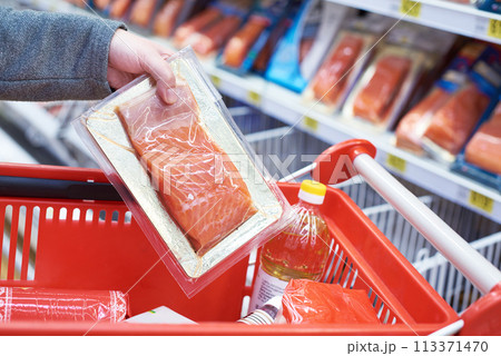 Pack of salmon in hand at store Pack of salmon in hand at store 113371470