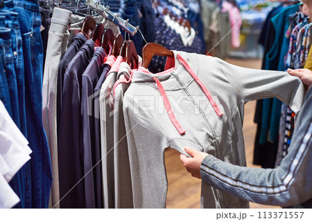 Buyer woman chooses clothes in store 113371557