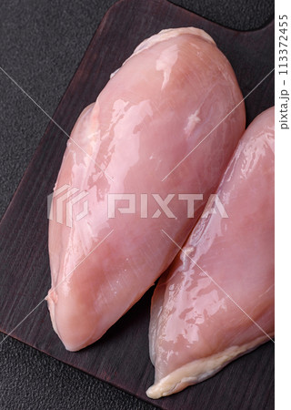 Fresh chicken fillet on a dark concrete table with spices and herbs Fresh chicken fillet on a dark concrete table with spices and herbs 113372455