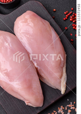 Fresh chicken fillet on a dark concrete table with spices and herbs Fresh chicken fillet on a dark concrete table with spices and herbs 113372458