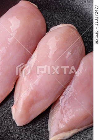 Fresh chicken fillet on a dark concrete table with spices and herbs 113372477
