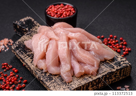 Slices of raw chicken or turkey fillet with salt, spices and herbs Slices of raw chicken or turkey fillet with salt, spices and herbs 113372513