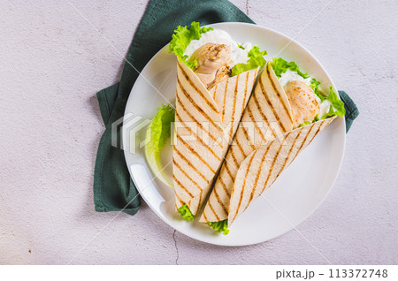 Close up of dietary grilled tacos with chicken fillet, lettuce on a plate on the table top view 113372748