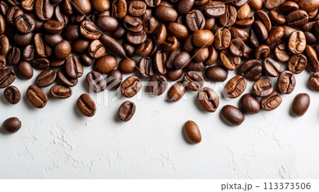 A pile of freshly roasted coffee beans on a white background, with organic beans scattered on a white table. A pile of freshly roasted coffee beans on a white background, with organic beans scattered on a white table. 113373506