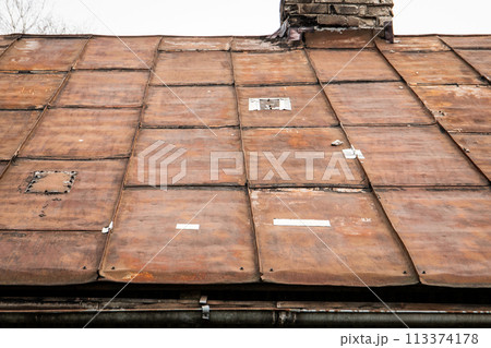 Old rusty metal roof with patches. Repair and renovation Old rusty metal roof with patches. Repair and renovation 113374178