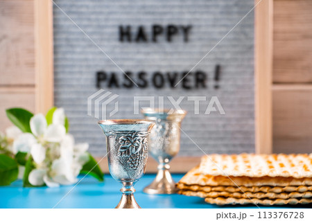 Happy Passover. Metal wine glasses and traditional Jewish matzo bread. Happy Passover. Metal wine glasses and traditional Jewish matzo bread. 113376728