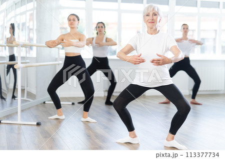 Elderly woman leading ballet class with female dancers 113377734