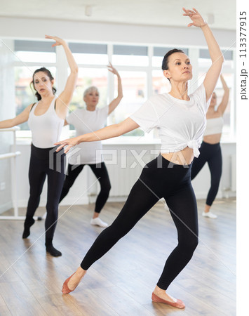 Experienced female ballet dancer rehearsing with group in studio Experienced female ballet dancer rehearsing with group in studio 113377915