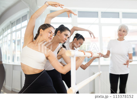 Elderly woman teacher corrects female dancers 113378152