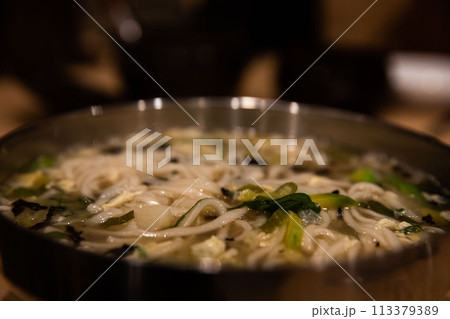 Kalguksu (noodle soup) made by kneading flour and cutting it with a knife to make noodles and boiling it with green onions and vegetables, a traditional Korean food Kalguksu (noodle soup) made by kneading flour and cutting it with a knife to make noodles and boiling it with green onions and vegetables, a traditional Korean food 113379389