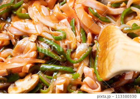 ピーマンと玉ねぎとマッシュルームとハムを炒める調理シーン。 113380330