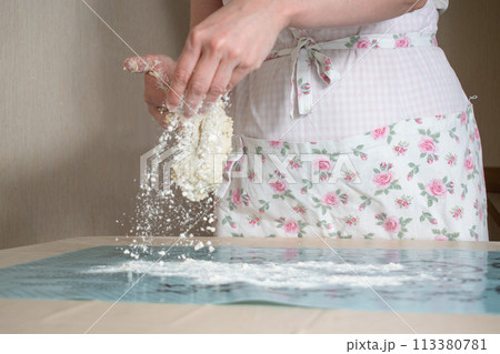 women's hands sprinkle the table with flour and put dough on it at studio women's hands sprinkle the table with flour and put dough on it at studio 113380781