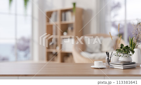 A wooden tabletop adorned set against a blurred background of a cozy Scandinavian living room. A wooden tabletop adorned set against a blurred background of a cozy Scandinavian living room. 113381641