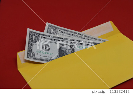 BBanknotes in a yellow envelope on a red background. Bribery concept. Salary in envelopes, fraud. BBanknotes in a yellow envelope on a red background. Bribery concept. Salary in envelopes, fraud. 113382412