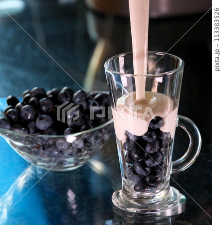 Pouring pink berry smoothie in glass. Healthy summer drink, berry milkshake or smoothie 113383526