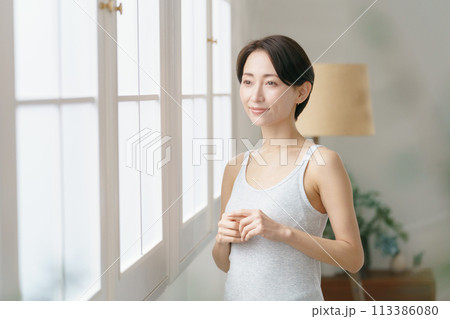 窓際に立つ30代の女性 113386080