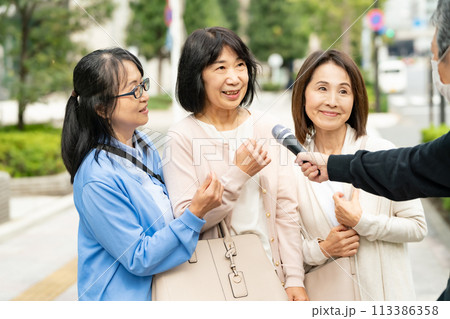 街頭インタビューに答える女性 113386358