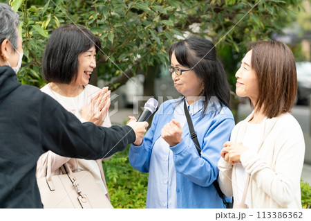 街頭インタビューに答える女性 113386362