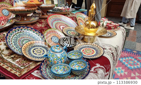 The showcase presents an assortment of colorful hand-painted ceramic tableware The showcase presents an assortment of colorful hand-painted ceramic tableware 113386930