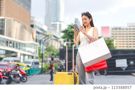 Asian woman using smartphone with luggage people city lifestyles travel with shopping 113388057