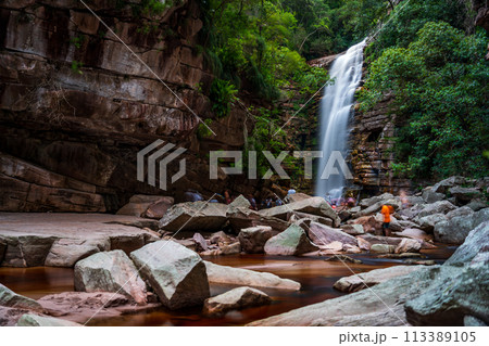 Serene Waterfall Oasis Amidst Rugged Rocks and Greenery 113389105
