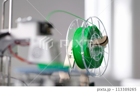 Green plastic string 3D printer consumable closeup 113389265