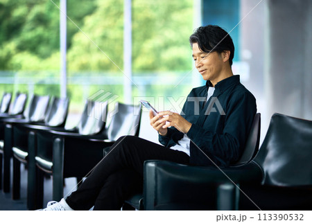 ラウンジでスマホを操作するビジネスマン 113390532