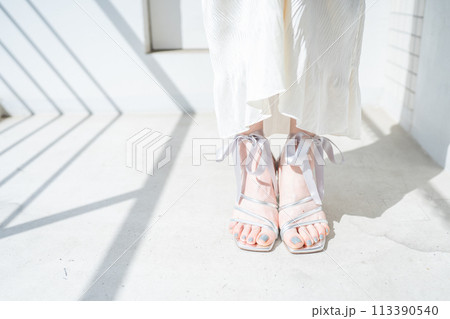 お洒落なサンダルを履く女性の足元 113390540