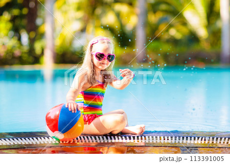 Child in swimming pool with ball. Kids swim. 113391005