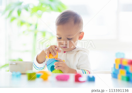 Baby boy playing with toy Baby boy playing with toy 113391136