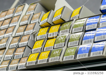 美容室の吊り下げラックに積まれた染毛剤（ヘアカラーチューブ）の箱	 113392250