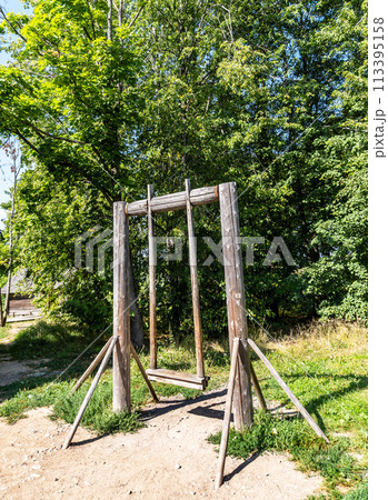 Old wooden swing in the Russian village on a sunny day Old wooden swing in the Russian village on a sunny day 113395158