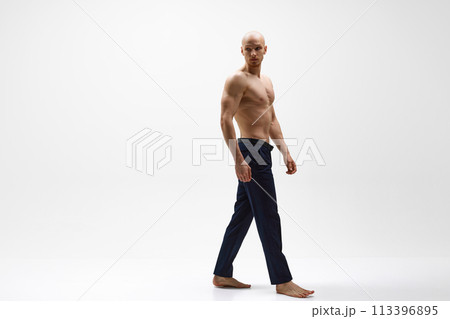 Full length portrait of young half-naked athletic man posing against grey studio background. Full length portrait of young half-naked athletic man posing against grey studio background. 113396895