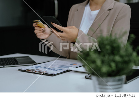 Female businessman use credit cards to conduct financial transactions through phones, tablet, and laptop. Female businessman use credit cards to conduct financial transactions through phones, tablet, and laptop. 113397413