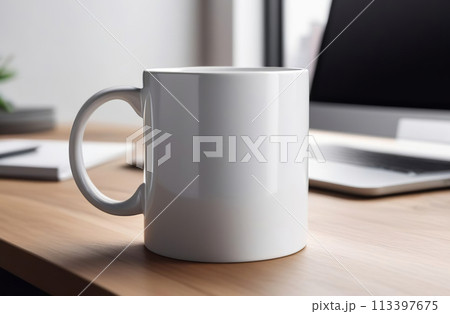 Mug Mock-Up. Blank white 11 oz ceramic cup is on a desk, office interior blurred background. Great for overlaying your custom quotes and designs for selling mugs. Notebooks on wooden table indoors. 113397675