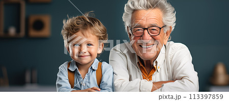 Grandfather and grandchild sitting together indoors. Grandfather and grandchild sitting together indoors. 113397859