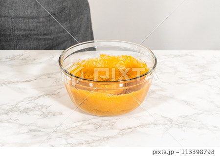 In a cozy kitchen, a large mixing bowl becomes the stage for expertly blending the ingredients, setting the scene for crafting a delightful homemade pumpkin bundt cake from cake mix. 113398798