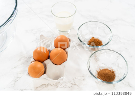 In a cozy kitchen, ingredients are meticulously measured in glass mixing bowls on the kitchen counter, all set to create a delightful homemade pumpkin bundt cake from cake mix. In a cozy kitchen, ingredients are meticulously measured in glass mixing bowls on the kitchen counter, all set to create a delightful homemade pumpkin bundt cake from cake mix. 113398849