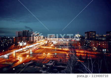 Urban Lights : A bustling urban landscape at dusk, where the fading daylight merges with the electric blurred buzz of streetlights and cars 113400710