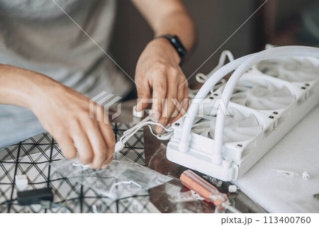 person engaged in assembling or working on computer hardware, likely involving precise technical work and attention to detail 113400760