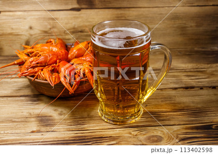 Boiled crayfish and mug of beer on a wooden table 113402598