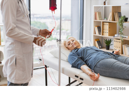 General practitioner checking tubes which blood flows of female. 113402986