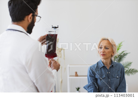 Caucasian senior woman making blood transfusions. Caucasian senior woman making blood transfusions. 113403001